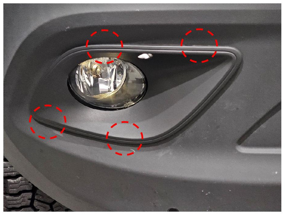 Fog light bezel release points around the factory fog light